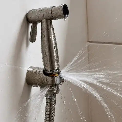 Douchette WC avec une grosse fuite, l'eau gicle dans tous les sens