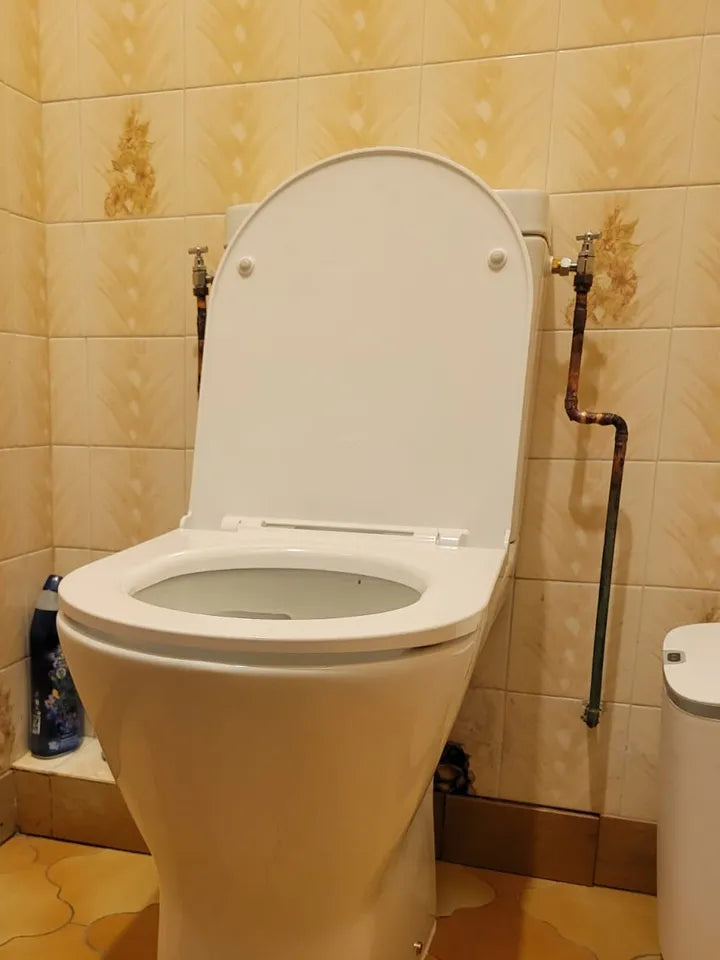 Arrivée d’eau rigide en angle chez un client : robinet d’équerre fixé au mur derrière le réservoir des toilettes (exemple 1)