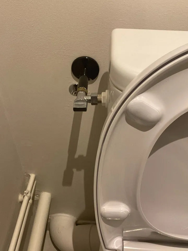 Arrivée d’eau rigide en angle chez un client : robinet d’équerre fixé au mur derrière le réservoir des toilettes (exemple 2)
