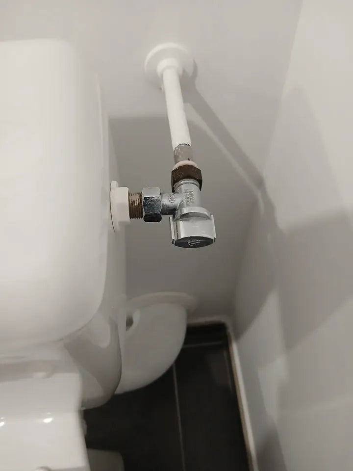 Arrivée d’eau rigide en angle chez un client : robinet d’équerre fixé au mur derrière le réservoir des toilettes (exemple 4)